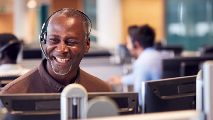 Customer care associate smiling whilst on the phone